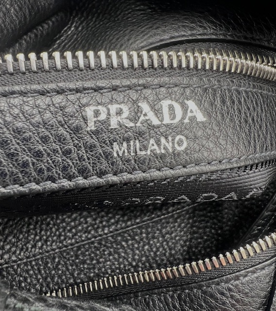 Bolso Prada tipo bucket en cuero negro con logotipo grabado