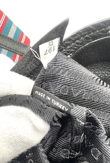 Bolso Prada tipo bucket en cuero negro con logotipo grabado