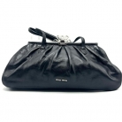 Borsa Miu Miu nera in pelle con chiusura con fiore metallico.