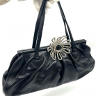 Borsa Miu Miu nera in pelle con chiusura con fiore metallico.