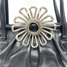 Borsa Miu Miu nera in pelle con chiusura con fiore metallico.