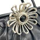 Borsa Miu Miu nera in pelle con chiusura con fiore metallico.