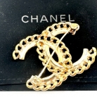 Broche Chanel dorado con pedrería.